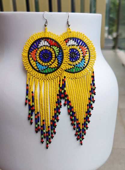 yellow beaded circle with tassels  on the bottom end of the earrings